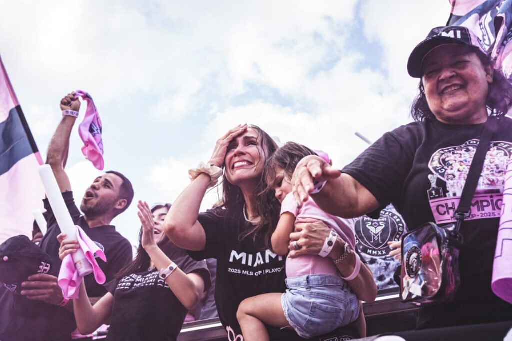 Family of fans cheering and celebrating in stadium stands
