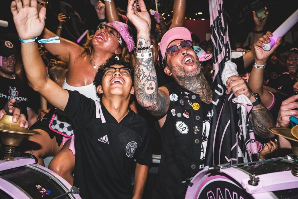 Supporters playing drums and cheering during a stadium event
