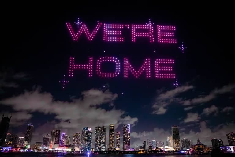 Drone light show spelling “We Are Home” above the Miami skyline at night