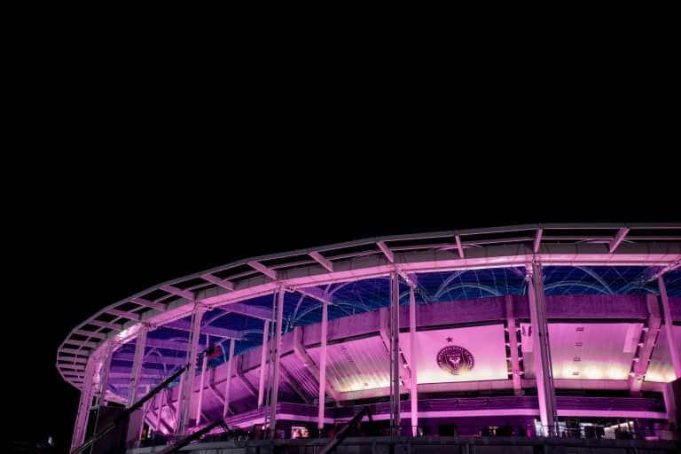 Nu Stadium exterior illuminated in pink lighting at night