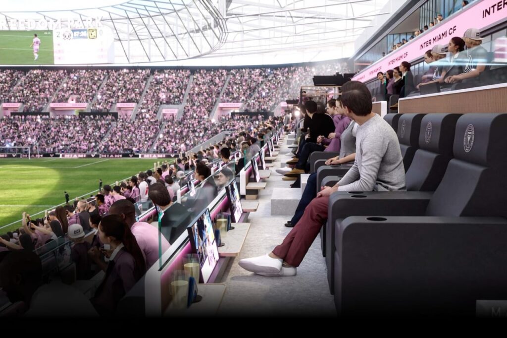 Premium seating area with fans watching soccer match from sideline