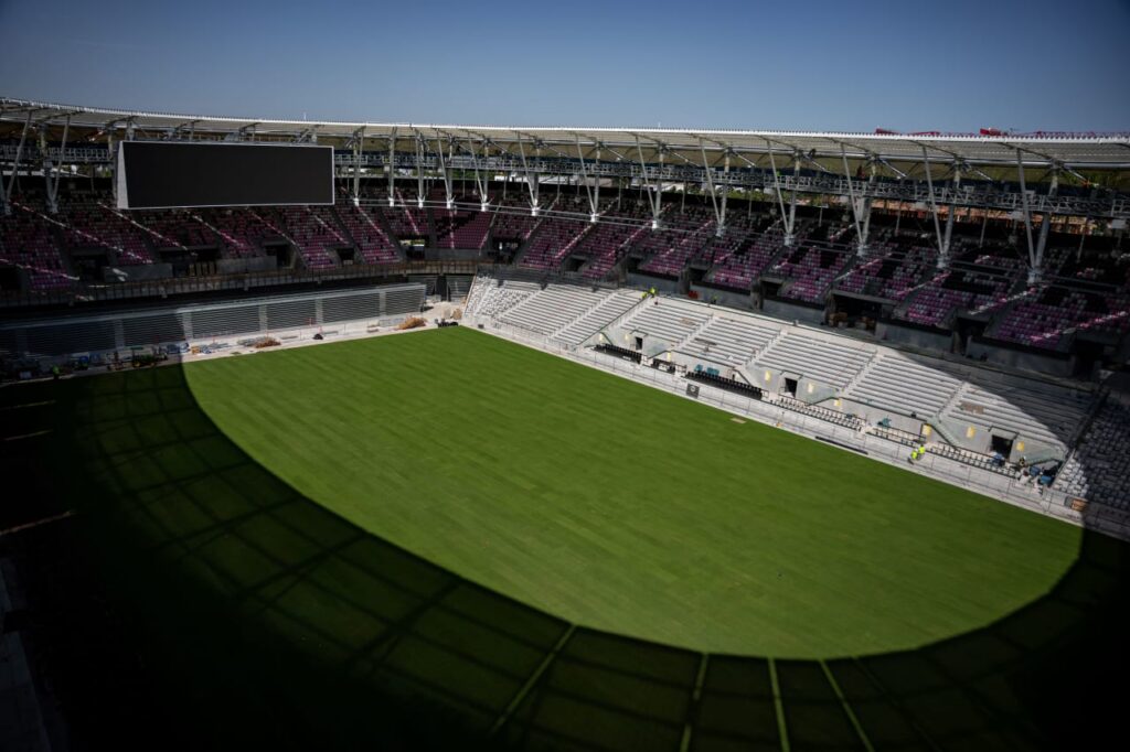 Wide interior view of stadium bowl with green field and seating sections