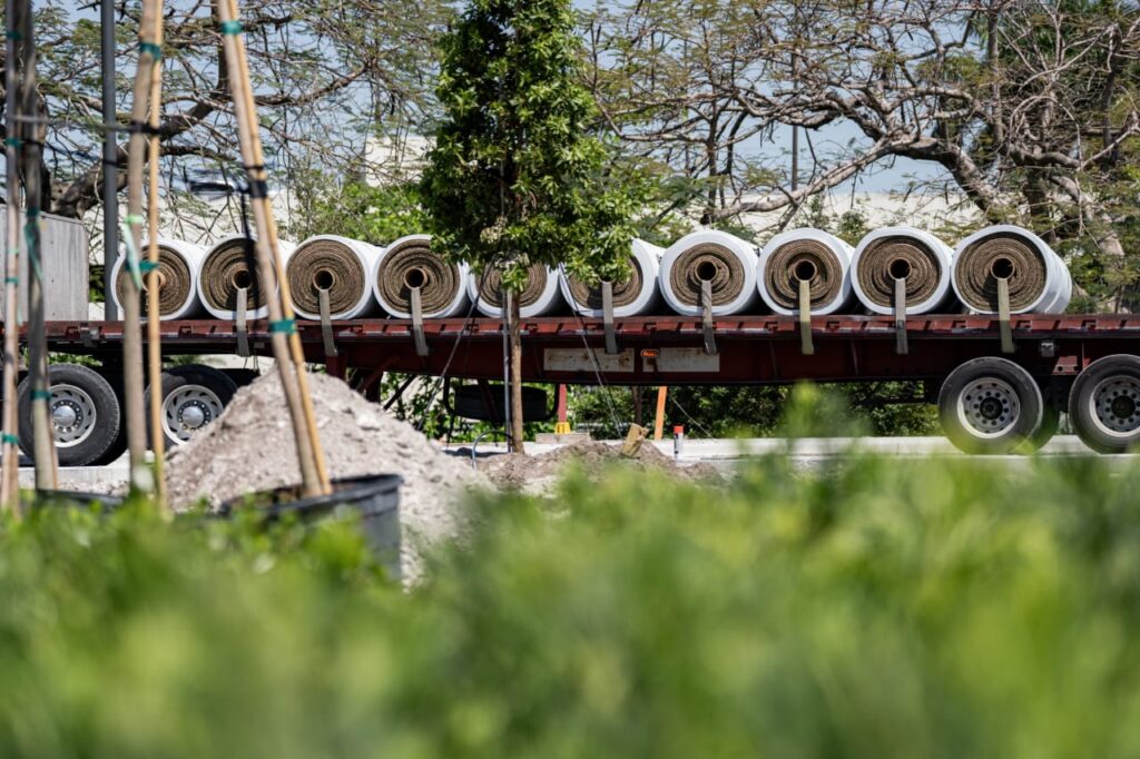 Rolls of turf loaded on truck near stadium construction site