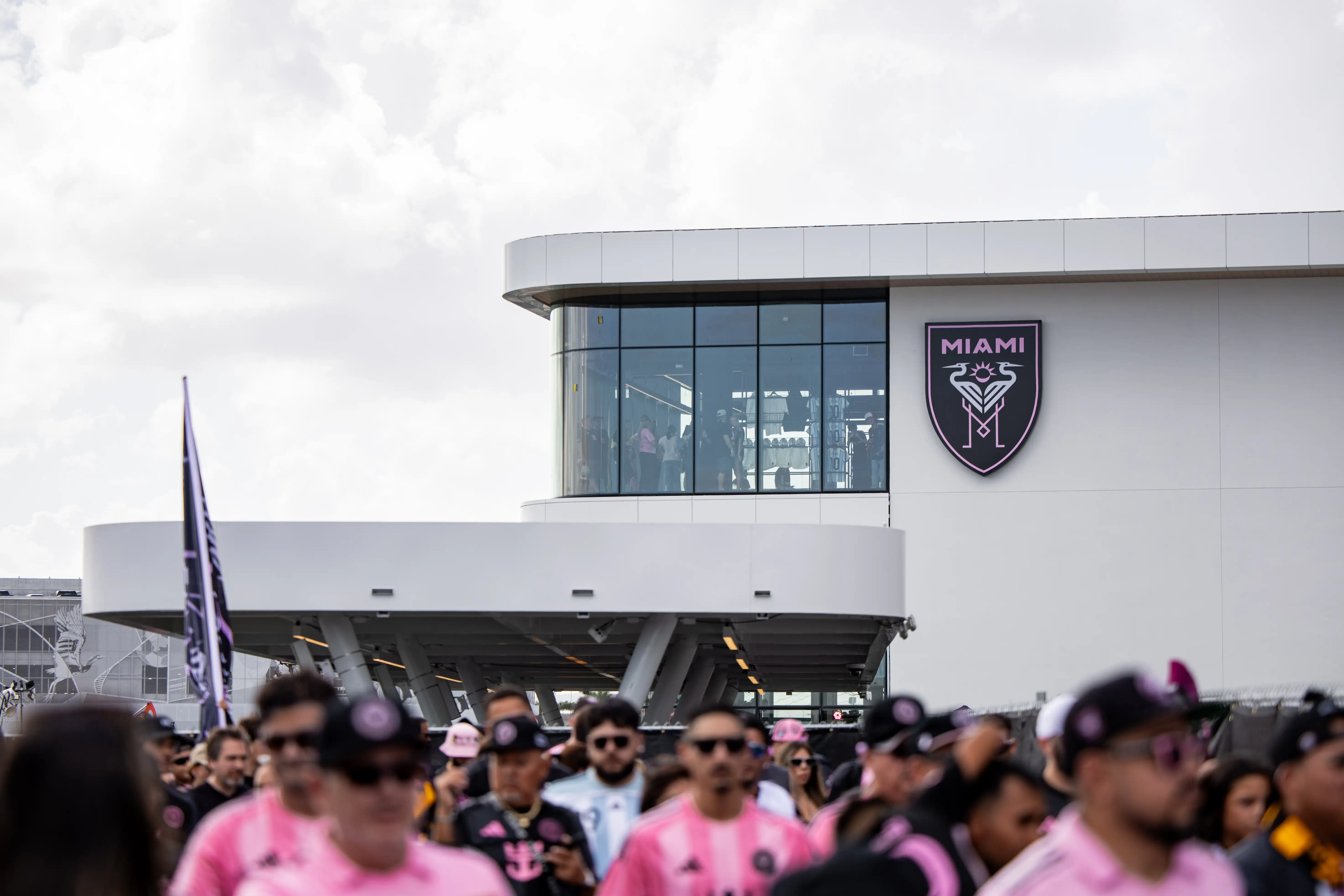 Crowds of Inter Miami fans walk toward the stadium entrance before a soccer match.