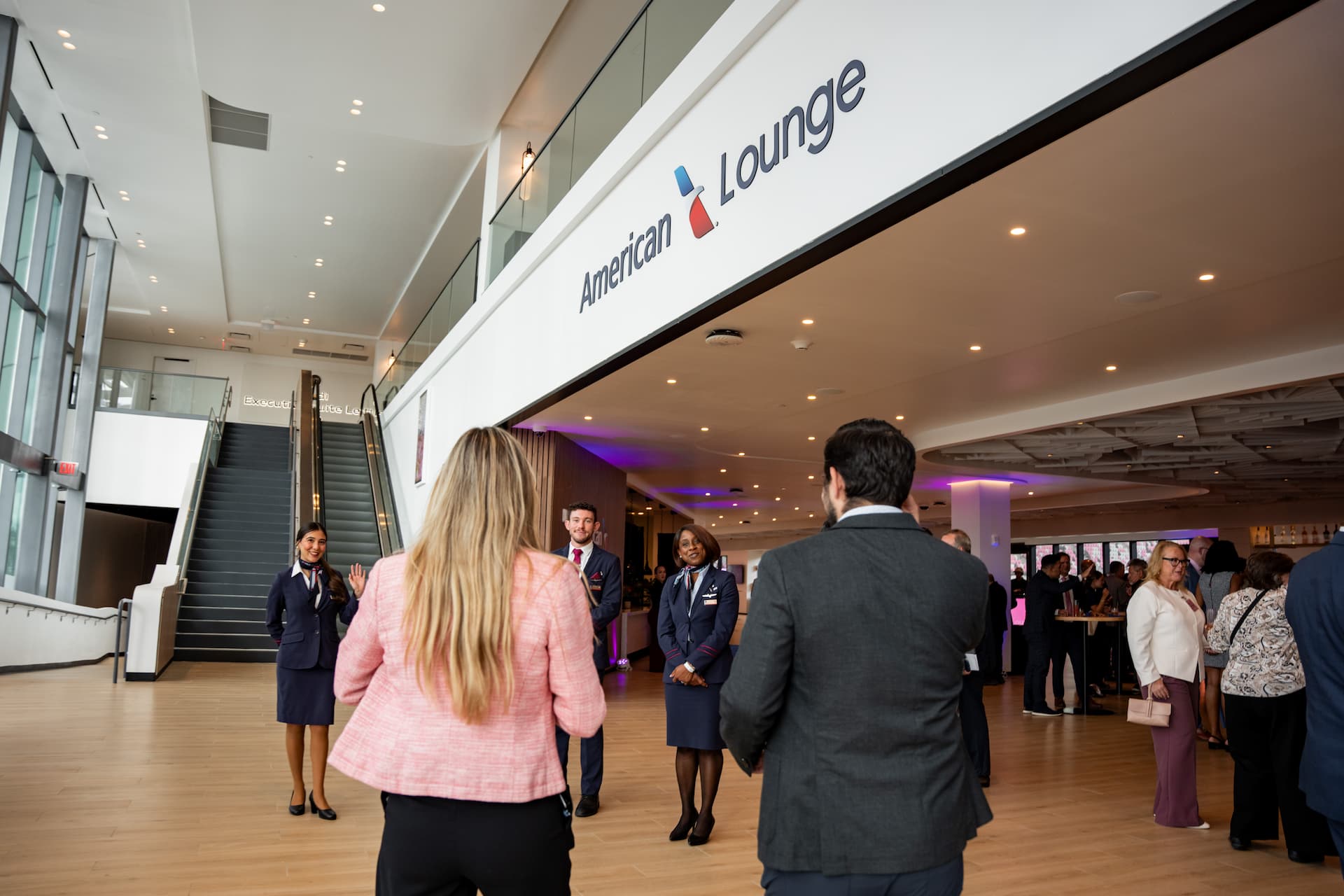 Guests arriving at the American Airlines Lounge at NU Stadium in Miami, welcomed by airline staff.