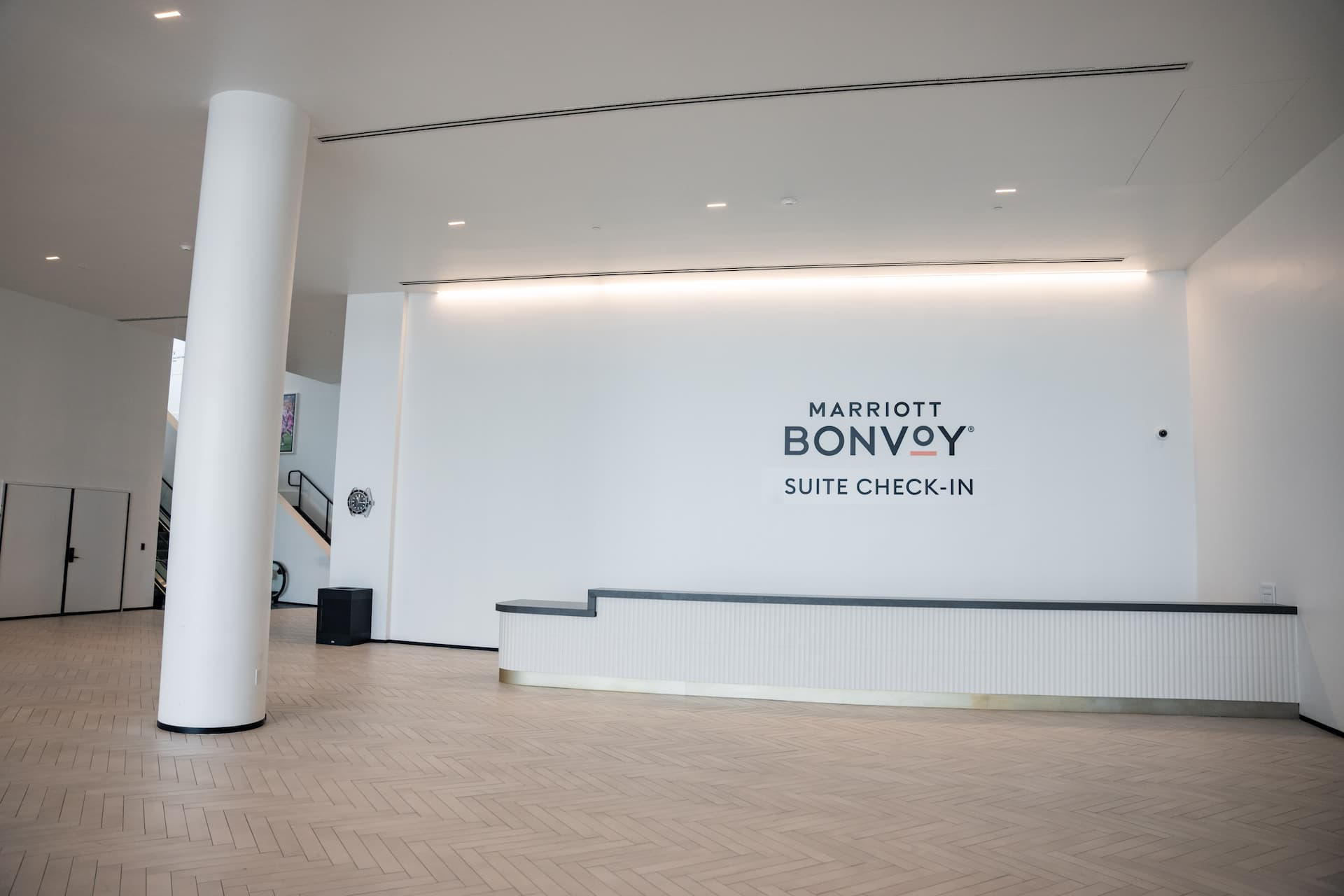 Marriott Bonvoy Suite Check-In area featuring a modern reception desk, white walls, and minimalist interior design.